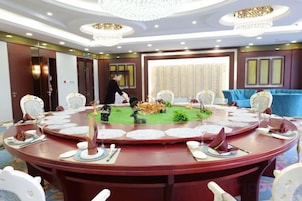 A conference room with a round table, chairs, and a person standing near the door.