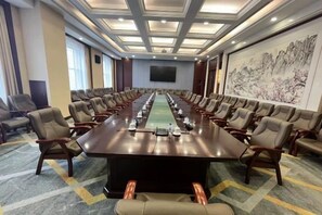 A conference room with a long table, multiple chairs, and a large screen. - Liaoyuan Hotel (Liaoyuan)