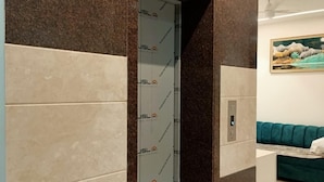 Un interior moderno con un mostrador de recepción, un sofá verde y un cuadro en la pared.