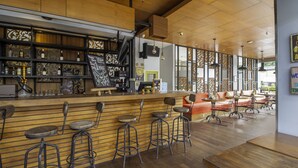 A bar area with stools, a counter, and shelves with bottles. - Palette Hotel near Padma (Legian)