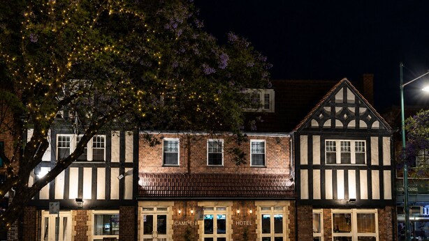 A traditional building with a sign reading 'CAMDEN HOTEL' and a visible entrance. - Camden Hotel Suites (Camden)
