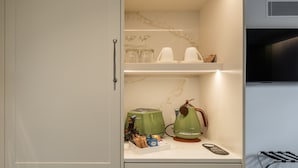 A kitchen with a built-in microwave, a toaster, and a kettle on the counter.