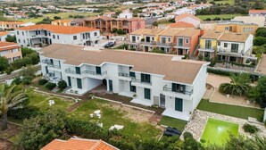 A residential area with modern houses, a well-maintained lawn, and a small pond. - 150 Meters From the Sea, 2 Swimming Pools (Valledoria)