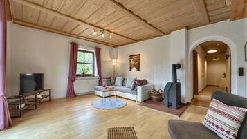 A cozy living room with a fireplace, a sofa, a television, and a dining area.