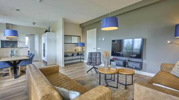 Un salon moderne comprenant un canapé, une table basse et un téléviseur.