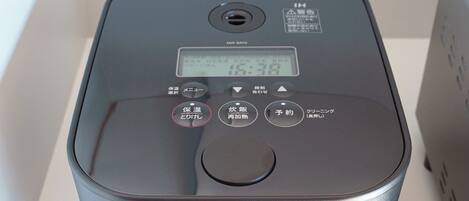 A compact, modern device with a digital display, buttons, and a ventilation hole.