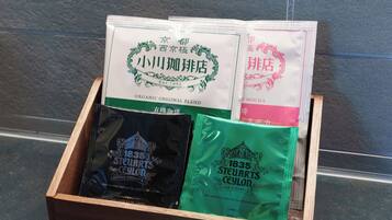 Une boîte en bois contenant des sachets de thé et un sachet de thé avec une étiquette.