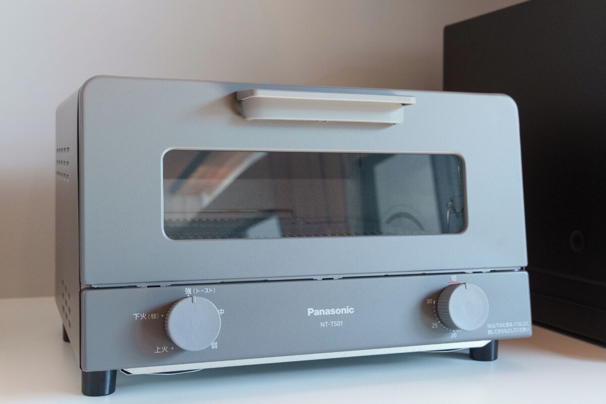 A Panasonic NT-T501 toaster oven with two control knobs and a glass door, placed on a white surface.