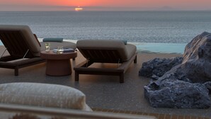 A sunset view from a beachside lounge with two lounge chairs and a small table, overlooking the ocean. - The Revery, Elafonisi - Member of Leading Hotels of the World (Kissamos)