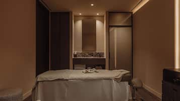 A hotel room with a bed, a vanity with a mirror, and a wardrobe.