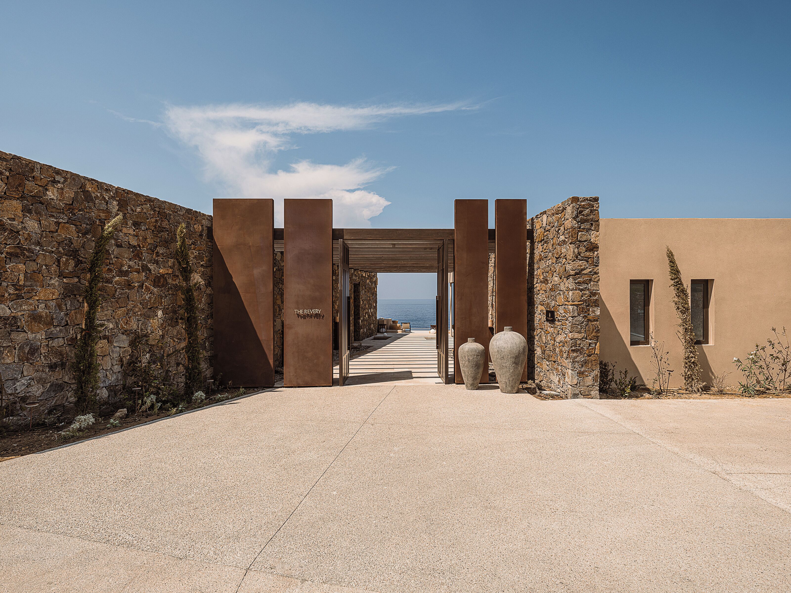 A pathway leading to a building with stone walls and a clear sky.
