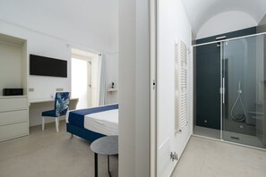 Un dormitorio moderno con cama, escritorio, silla y vestidor.