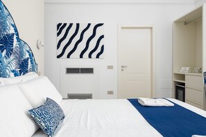 Une chambre d’hôtel avec un lit, une bouche d’aération, une porte et un petit coin salle de bain.