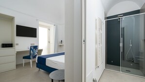 Un dormitorio moderno con cama, escritorio, silla y vestidor.