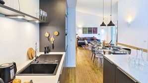 Een moderne keuken met een centraal eiland, een zithoek met een bank, en uitzicht op een stadsbeeld.