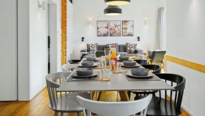 A dining area with a long table, chairs, and a hanging pendant light. - Wonderful private villa for 8 people with WIFI, TV and terrace (Diepholz)