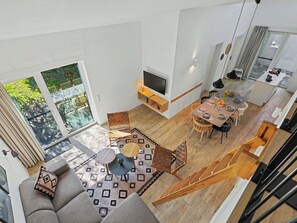 Ein modernes Interieur mit Essbereich, Sofa und Treppe.