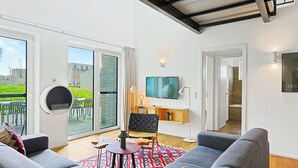 Ein modernes Wohnzimmer mit einer Couch, einem Fernseher und einem Kamin.