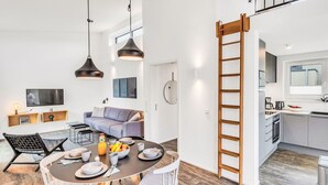 Um apartamento moderno com área de jantar, cozinha e sala de estar.