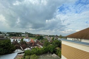 Un barrio residencial con casas, algo de vegetación y un cielo nublado.