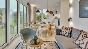 A modern apartment with a dining area, kitchen, and living room. - Lovely apartment for 6 people with WIFI, TV, balcony and pets allowed (Diepholz)