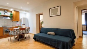 A compact living space with a kitchenette, a dining area, and a sofa. - Beautiful apartment for 4 people with A/C, WIFI, TV and pets allowed (Pisa)