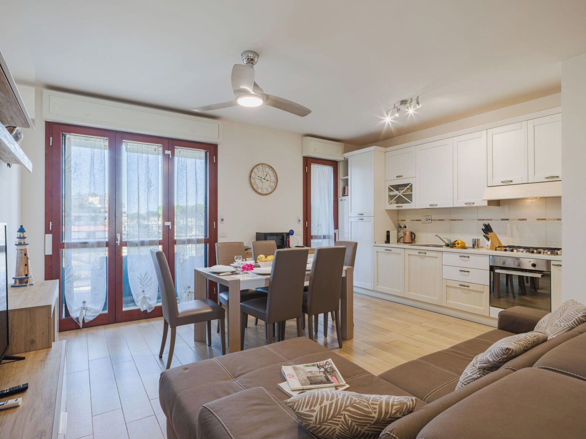 A modern apartment with a dining area, kitchen, and living room.