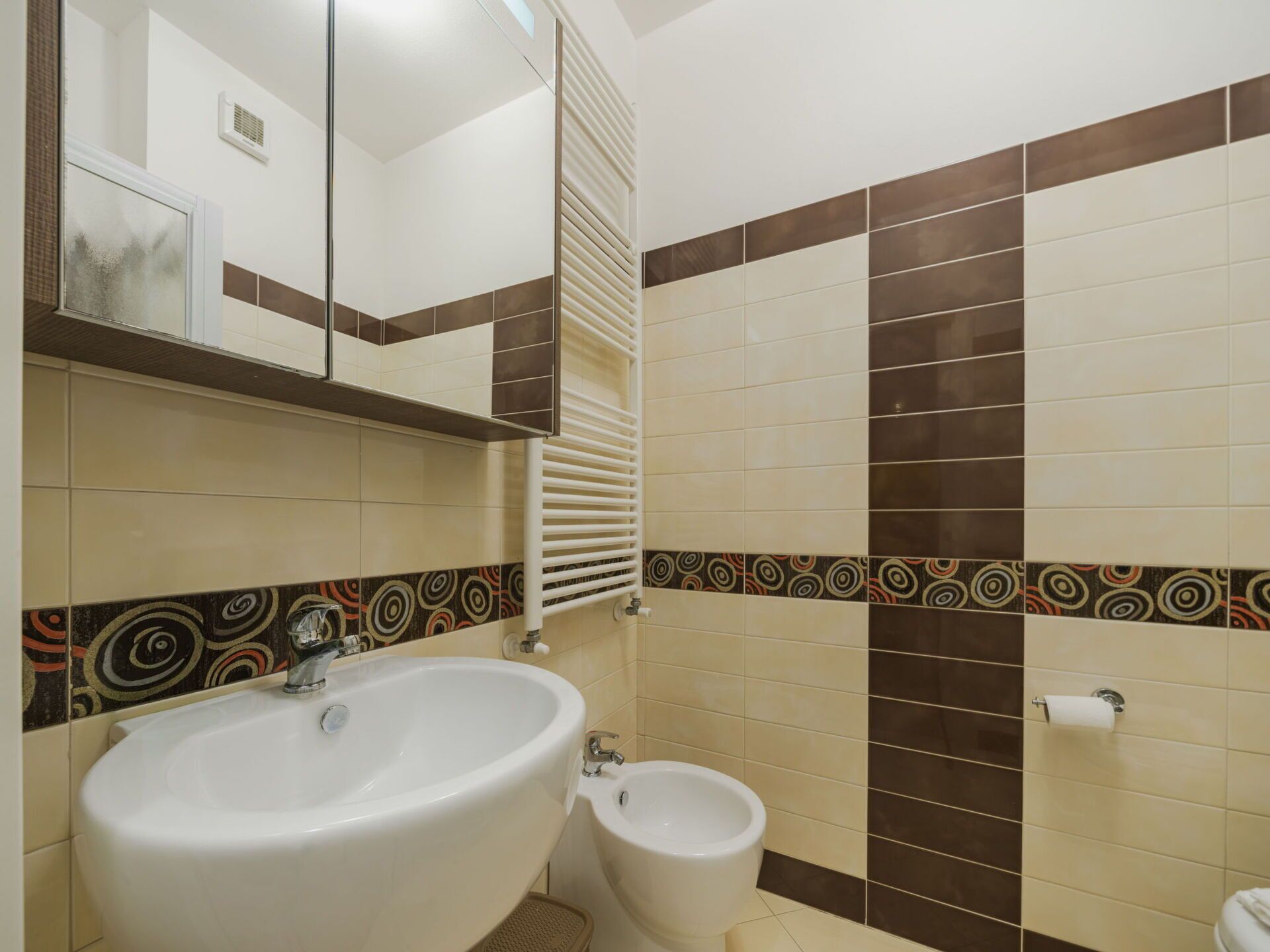 A bathroom with a large sink, a small toilet, and a mirror above the sink.
