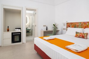 Ein Hotelzimmer mit Bett, Schreibtisch, Spiegel und Minibar.