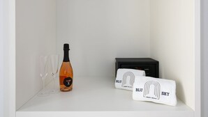 Un estante blanco con una botella de champán, dos copas y una toalla con el texto 'BLU SKY LUXURY PALACE'.