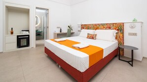 Habitación de hotel con cama, escritorio, silla, mesita y espejo.