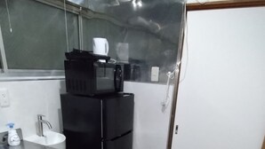 Una cocina compacta con un lavamanos, un microondas y un refrigerador.
