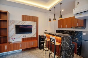 Quarto standard | Cozinha privada | Geladeira, cooktop, lava-louças, mesas de jantar