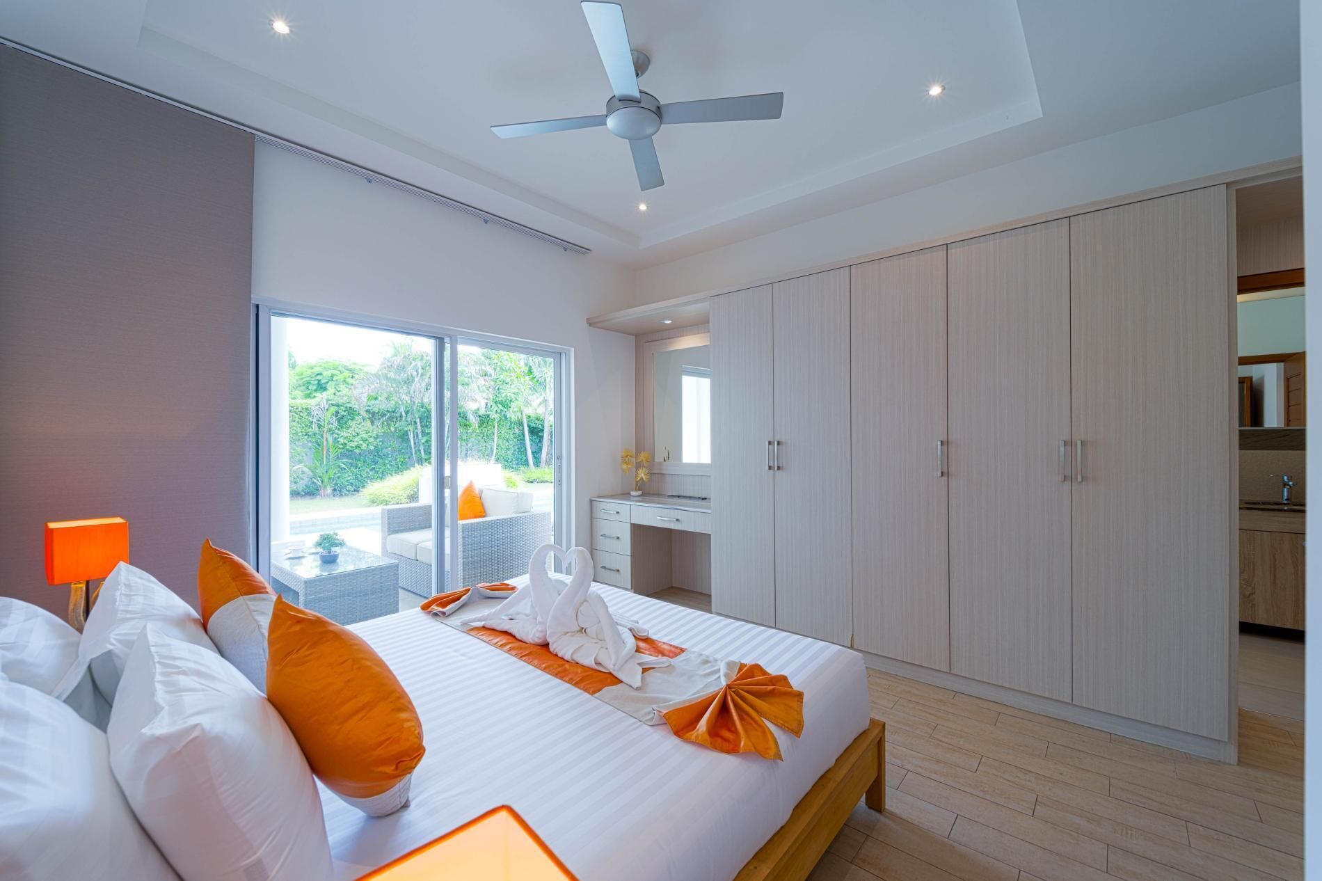 A modern bedroom with a bed, a desk, and a wardrobe.