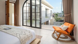 Een moderne slaapkamer met een groot bed, een balkon met uitzicht en een schuifdeur van glas.