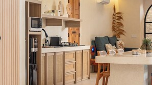 Een moderne keuken met een centraal kookeiland, houten kastjes en een magnetron.