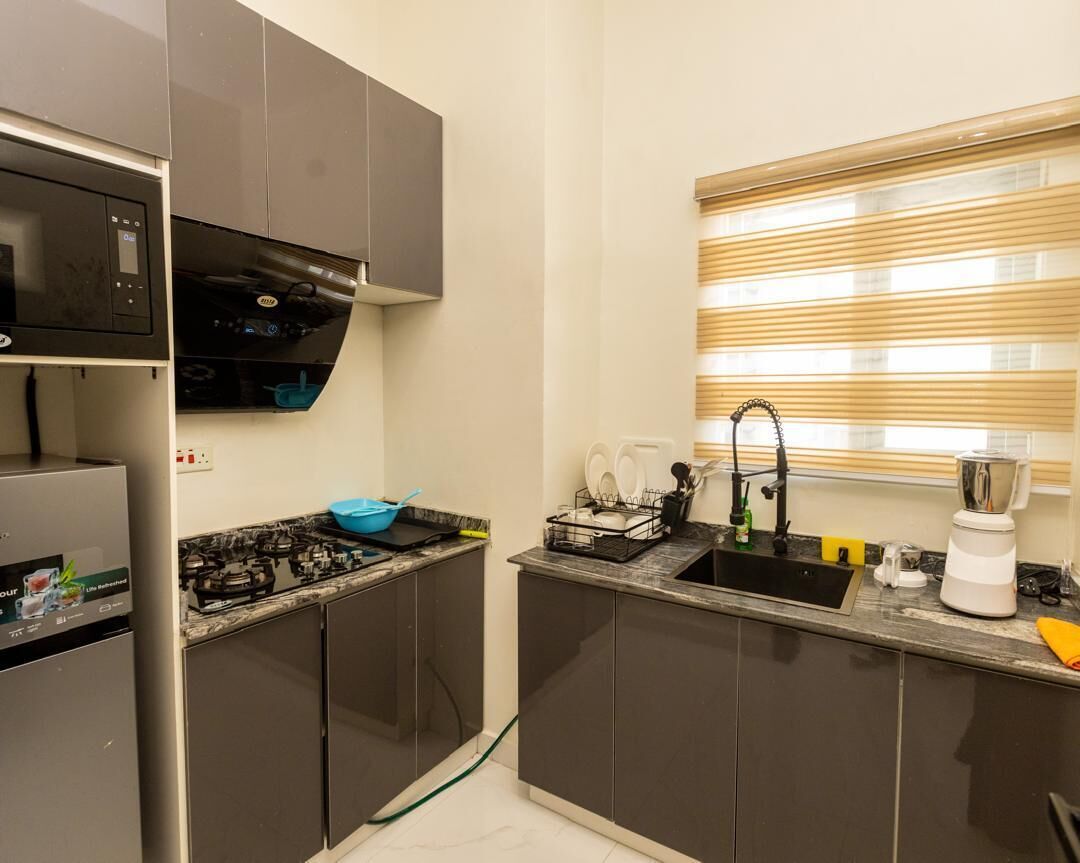 A compact kitchen with a built-in microwave, gas stove, and a sink with a window above.
