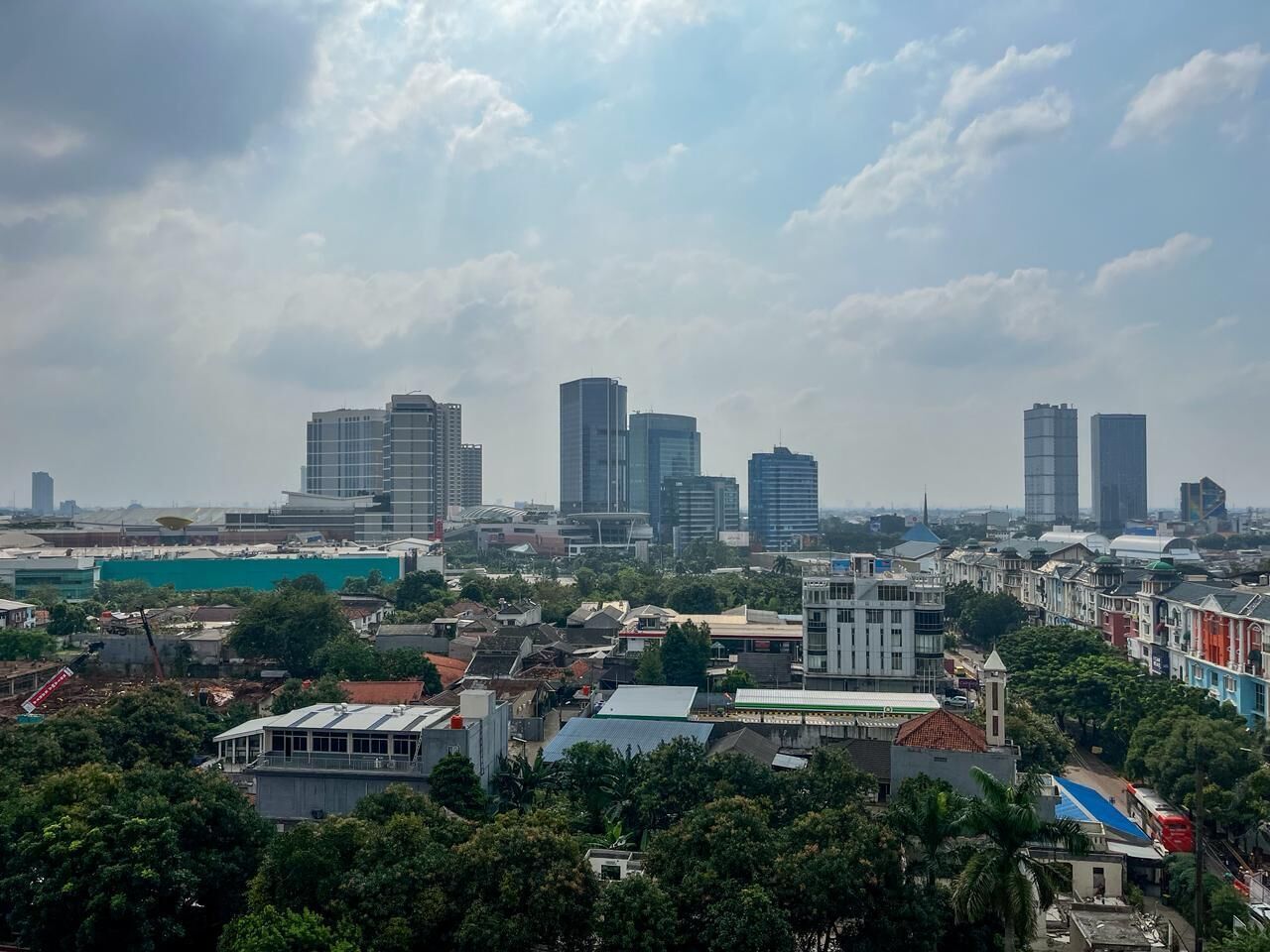 Un paysage urbain caractérisé par de nombreux immeubles de grande hauteur, un mélange de bâtiments résidentiels et commerciaux, et un environnement urbain dense.