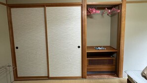 A traditional Japanese-style room with sliding doors, a wooden shelf, and a hanging rack. - Hotel Davos Hakuba (Hakuba)