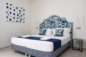 A bed with a patterned headboard, a bedside table, and a wall art piece.