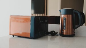 A kitchen with a toaster and a coffee maker on a countertop.