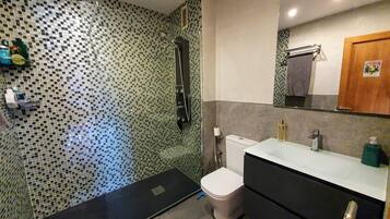 Een haardroger, handdoeken, zeep, toiletpapier