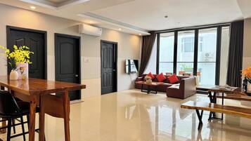 Departamento Deluxe, 2 habitaciones, vista a la ciudad | Área de sala de estar | Televisión LED de 55 pulgadas con canales por cable