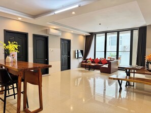 Departamento Deluxe, 2 habitaciones, vista a la ciudad | Área de sala de estar | Televisión LED de 55 pulgadas con canales por cable 