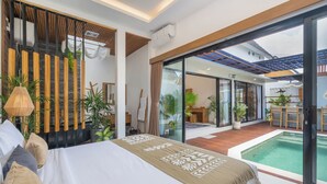 Ein modernes Schlafzimmer mit einem großen Bett, Blick auf einen Swimmingpool und einer Glastür, die zu einer Terrasse führt.