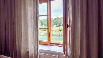 A room with a large window, curtains, and a radiator.
