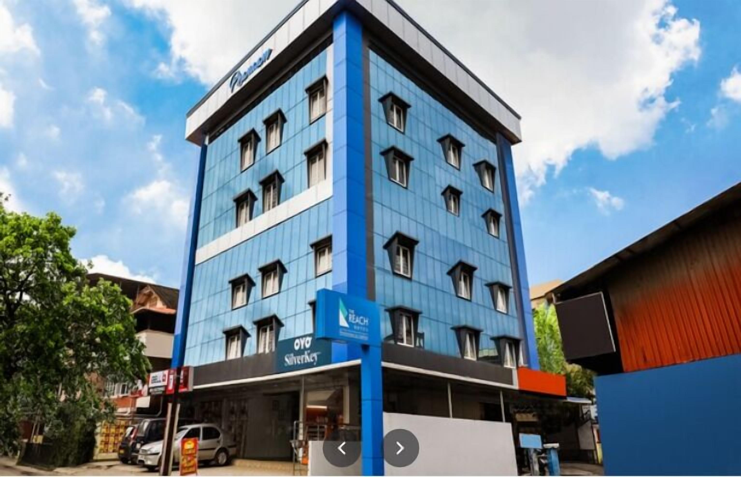 A multi-story hotel with a blue facade and a sign for 'OYO Silverback' on the ground floor.