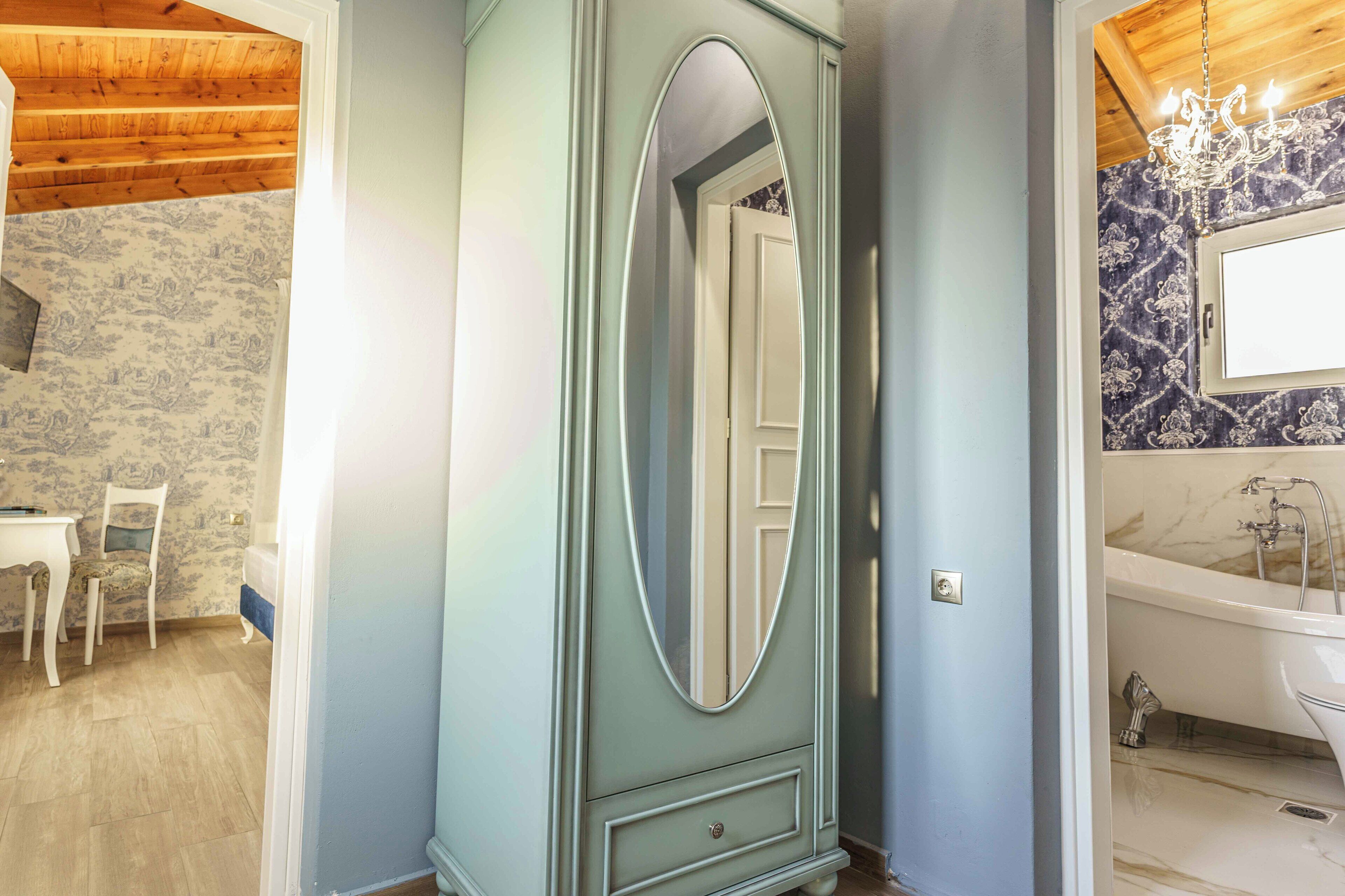 Un bagno con una vasca freestanding, uno specchio e un lampadario.