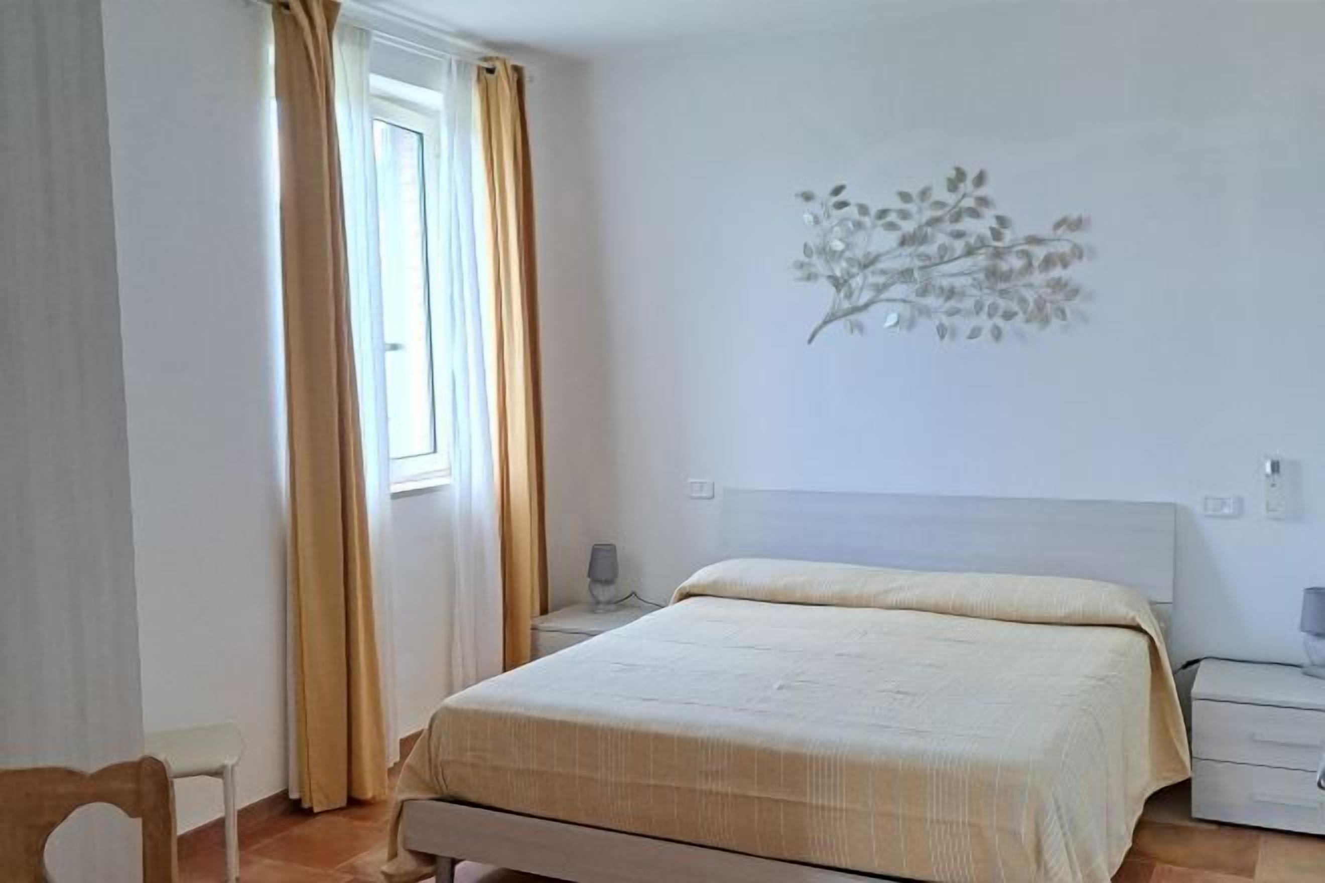 Une chambre à coucher comprenant un lit, une table de chevet, une chaise et un élément décoratif mural.