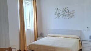 Une chambre à coucher comprenant un lit, une table de chevet, une lampe et un élément de décoration fixé au mur.